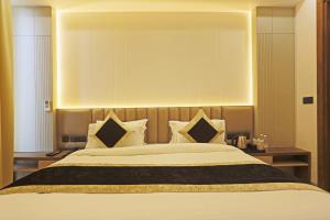 a bedroom with a large bed with white sheets and pillows at Hotel Mehul Int-New Delhi in New Delhi