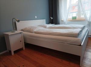 een slaapkamer met een bed met een lamp en een raam bij Emely Ferienwohnung in Röbel