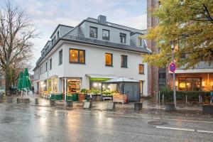 un edificio blanco al lado de una calle en Business Apartment Kranich: 3 Zimmer, Top Infrastrukturlage HH Langenhorn, Nähe Airport, en Hamburgo