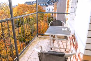 a table and a chair on a balcony at Rothenberger Plauen in Plauen