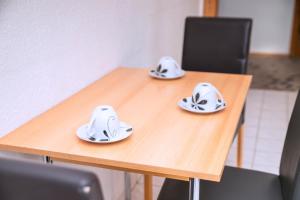 a wooden table with two plates on top of it at Rothenberger Plauen in Plauen