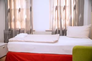 a bedroom with a white bed with a red blanket at Rothenberger Plauen in Plauen