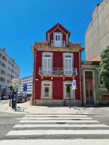 een rood gebouw op de hoek van een straat bij Vintage Beach House in Matosinhos