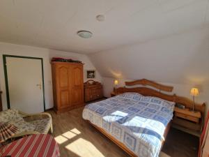 um quarto com uma cama, uma cadeira e um armário em Haus Sievertsen Whg1 em Wyk auf Föhr