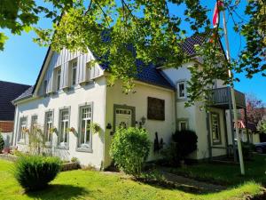 uma casa branca com um telhado azul em Haus Sievertsen Whg1 em Wyk auf Föhr