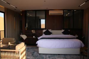 a bedroom with a large bed and a chair at Oman desert private camp in Shāhiq