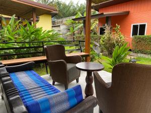 un patio con sillas, una mesa y un sofá en Coconut Lanta Resort @Klong Dow beach, en Krabi