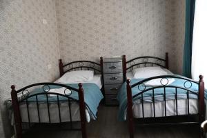 two twin beds in a room with wallpaper at Babulya House in Gyumri