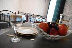 a table with a bowl of fruit and wine glasses at Babulya House in Gyumri