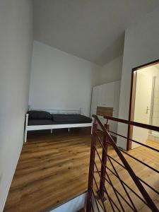 una camera vuota con un letto e un pavimento in legno di FERIENWOHNUNG APARTMENT 2 RAUM MAISONETTEN WOHNUNG im ZITTAUER STADTZENTRUM INNENSTADT INNENRING TOP LAGE MARKT UND RATHAUS NÄHE a Zittau