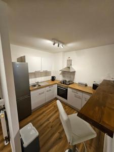 una cucina con armadietti bianchi e pavimenti in legno di FERIENWOHNUNG APARTMENT 2 RAUM MAISONETTEN WOHNUNG im ZITTAUER STADTZENTRUM INNENSTADT INNENRING TOP LAGE MARKT UND RATHAUS NÄHE a Zittau