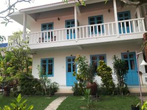 una casa con porte blu e balcone di Nhat Quang Bungalow a Mui Ne