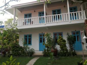 una casa con porte blu e balcone di Nhat Quang Bungalow a Mui Ne