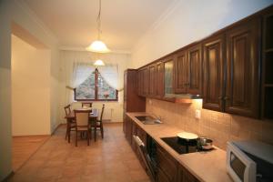 a kitchen with wooden cabinets and a table in it at Slunecni Lazne Apartments in Karlovy Vary