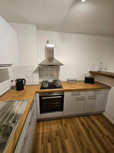 una cucina con piano cottura e piano di lavoro di FERIENWOHNUNG APARTMENT 2 RAUM MAISONETTEN WOHNUNG im ZITTAUER STADTZENTRUM INNENSTADT INNENRING TOP LAGE MARKT UND RATHAUS NÄHE a Zittau