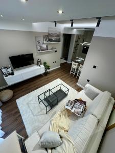 a living room with a white couch and a table at Premium Line Apartman in Sombor