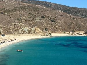 um barco na água ao lado de uma praia em Villa Il Paradiso Andros em Gavrio