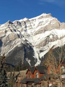 une maison en face d'une montagne enneigée dans l'établissement Hillside Bungalows, à Banff