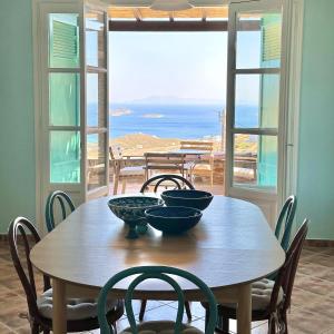 uma mesa com quatro taças com vista para o oceano em Villa Il Paradiso Andros em Gavrio