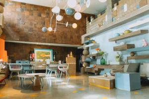 a dining room with tables and chairs in a room at IKOSHAROLD Suites Seminyak in Seminyak