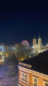 una vista de la ciudad por la noche con una noria en Rest House Apartman, en Nyíregyháza