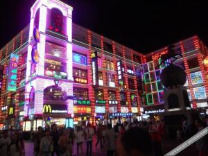 um grande edifício com luzes coloridas à noite em City Comfort Inn Guangzhou Shisanhang Shangxiajiu Pedestrian Street 1st Branch em Guangzhou