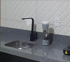 a kitchen counter with a sink and a mixer at Casa de 2 quartos com ar, banheiros, pátio, mobília, tudo privativo - Projeto Suítes que Desconta duração e entra 15h adiante inclusive à noite in Sorriso