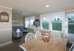 een woonkamer met een tafel en stoelen en een bank bij Owls Head Cottage at One Long Beach in York Beach