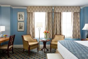 una camera d'albergo con un letto e due sedie e una scrivania di Francis Marion Hotel a Charleston