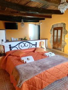 ein Schlafzimmer mit einem großen Bett mit orangefarbener Bettwäsche in der Unterkunft Casa del Ghetto in Pitigliano