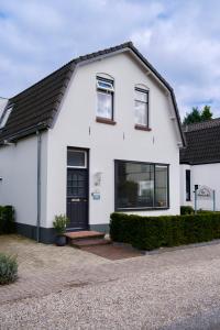 een wit huis met een zwarte deur bij B&B De Mansarde in Apeldoorn