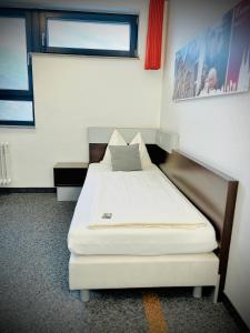 een kamer met een bed in een kamer met een raam bij Jugendherberge City-Hostel Köln-Riehl in Keulen