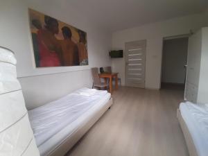 um quarto com uma cama e um quadro na parede em APARTAMENTY ZIELONY KAMELEON em Busko-Zdrój