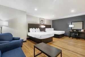 een hotelkamer met 2 bedden en een bank bij Best Western Mystic Hotel in Mystic