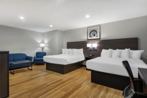 een hotelkamer met 2 bedden en een stoel bij Best Western Mystic Hotel in Mystic