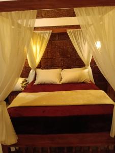 a bedroom with a bed with white curtains at Wild Part in Sultan Bathery