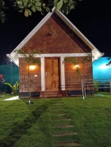 a small brick house with lights in the grass at Wild Part in Sultan Bathery