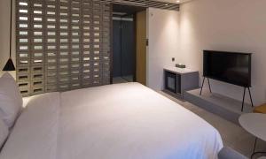 a bedroom with a bed and a flat screen tv at Cont Hotel in Busan