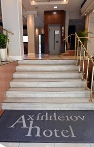 eine Lobby eines Hotels mit einem Schild auf der Treppe in der Unterkunft Hotel Achillion in Larisa