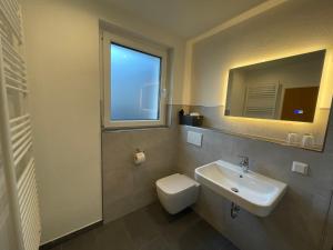 a bathroom with a sink and a toilet and a window at Berghotel Hohegeiß in Hohegeiß