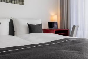 una camera con letto e scrivania con lampada di Garner Hotel Berlin - Gendarmenmarkt by IHG a Berlino