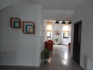 sala de estar con sofá y pinturas en la pared en Villa AnnaLia - Rooms to Rent, en Bacău