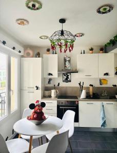 een keuken met witte kasten en een tafel met een knuffeldier erop bij THE ENCHANTED HOUSE ( 15 min walk to Disney) in Serris