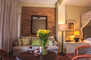 a living room with a couch and a table with flowers at Quinta Maria Cortez in Puerto Vallarta