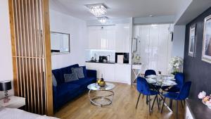 sala de estar con sofá azul y mesa en Crystal Baltic 222, en Dziwnówek