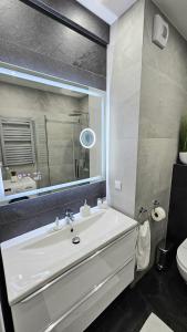 y baño con lavabo blanco y espejo. en Crystal Baltic 222, en Dziwnówek