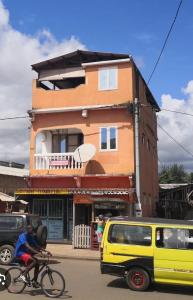 una persona montando una bicicleta delante de un edificio en Micaval Residential, en São Tomé