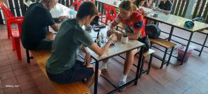 a group of people sitting at a table in a restaurant at Aurora Backpackers Hostel in Luang Prabang