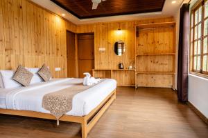 1 dormitorio con 1 cama en una habitación con paredes de madera en ZACS VALLEY RESORT, Kodaikanal, en Kodaikanal