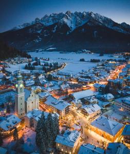 una vista aérea de una ciudad en la nieve por la noche en Hotel Gratschwirt, en Dobbiaco